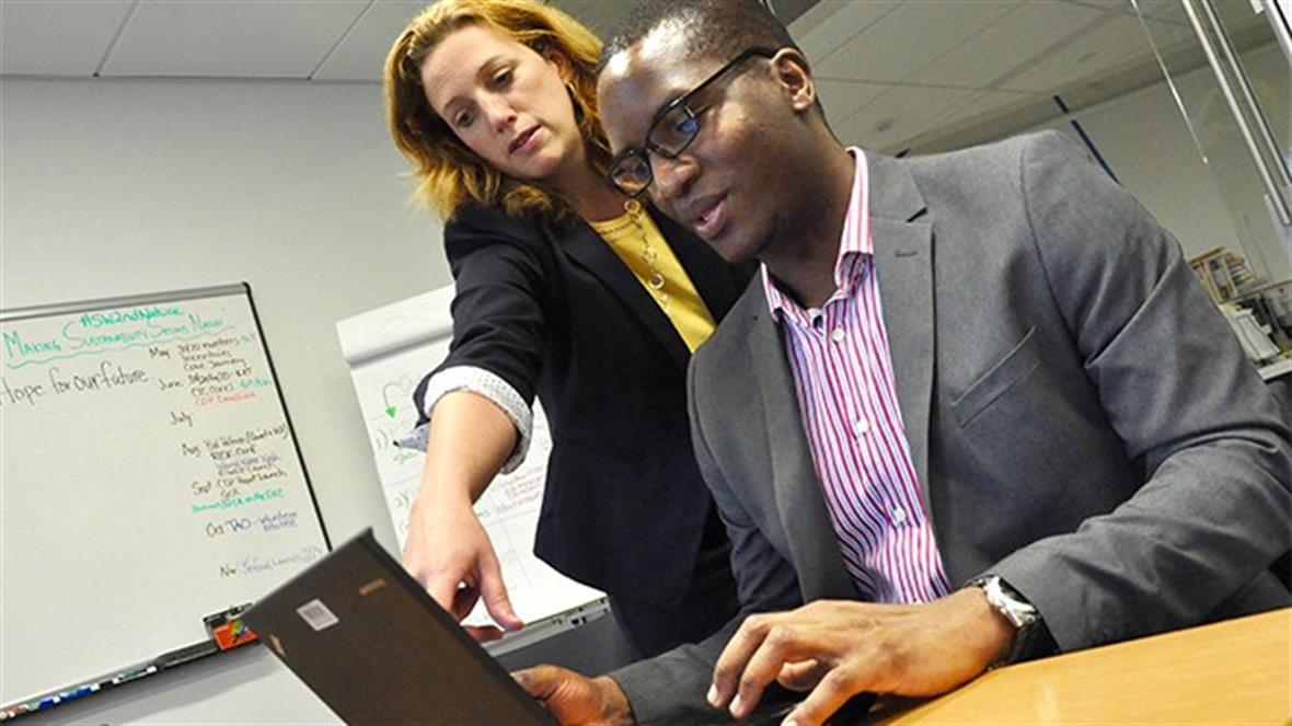 UD doctoral student Joseph Nyangon discusses energy-use data with Andrea Pinabell