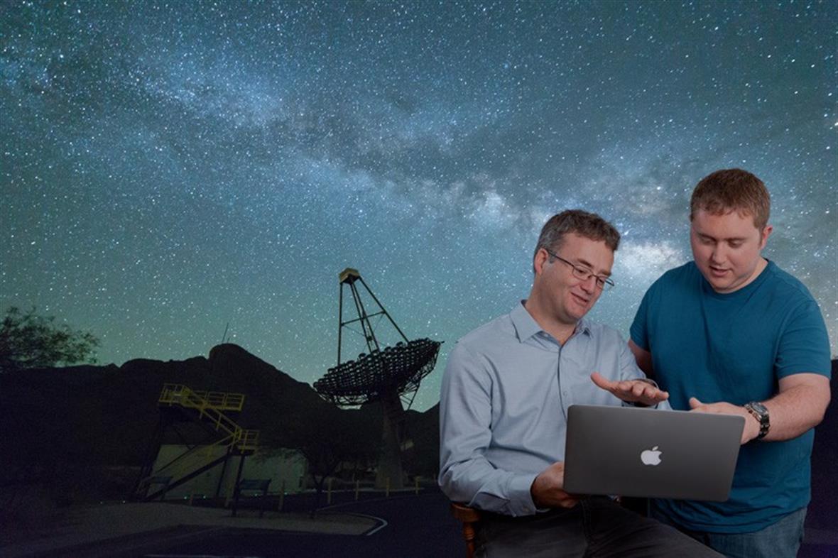 Two astronomers in front of telescope