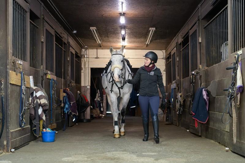 Tett walks her horse in the stable