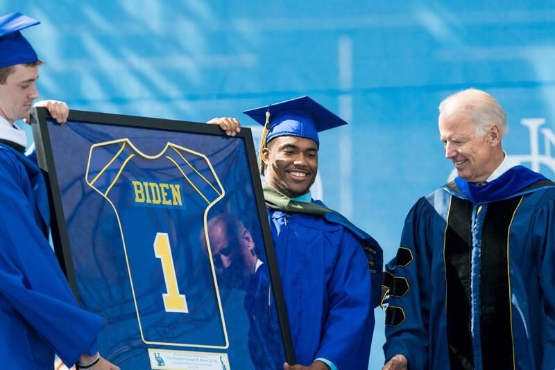 Graduating football players Justin Burns (left) and Andrew Pierce presented then-Vice President Joe Biden with a jersey during Biden’s 2014 Commencement address at Delaware Stadium.