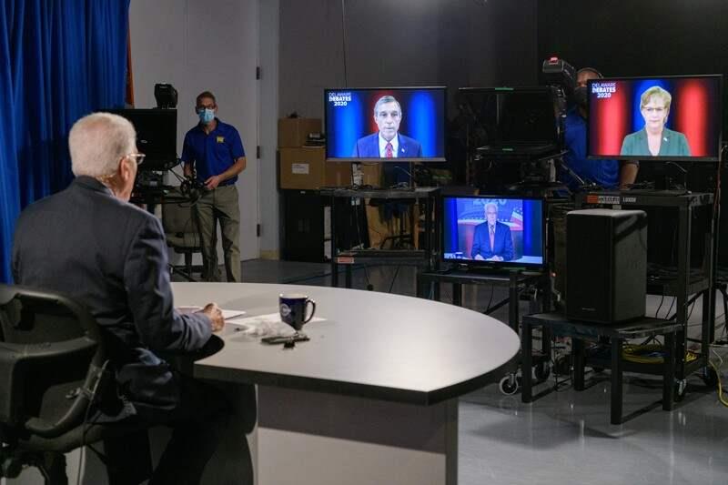 Moderator facing candidates on screens