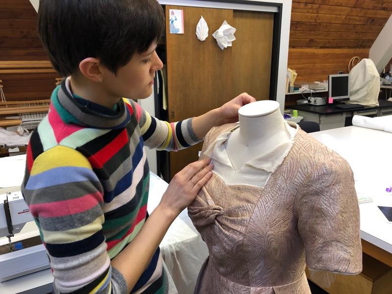 Student adjusts dress on mannequin