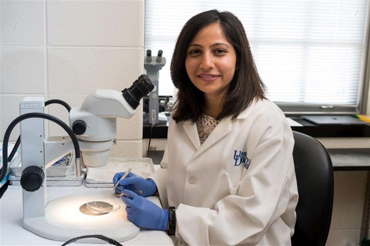 Shaili Patel sits at a microscope in a lab