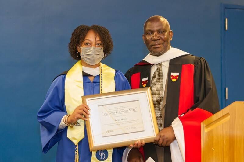 two people in academic regalia holding a certificate