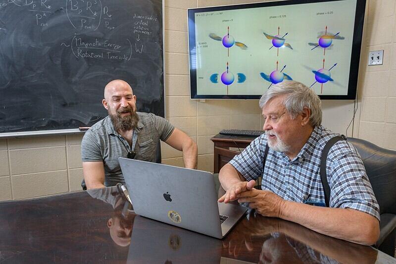 Two researchers at a laptop