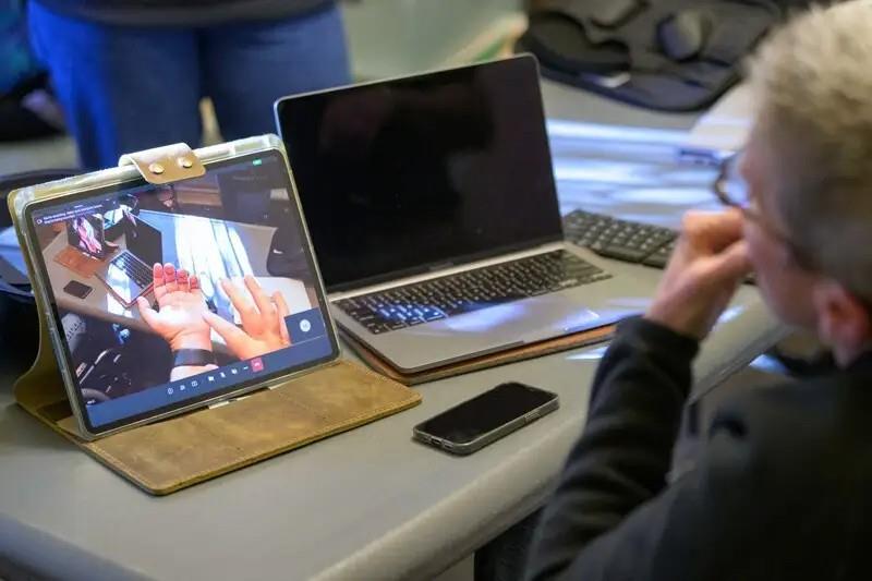 A tablet displaying a real-time image of hands