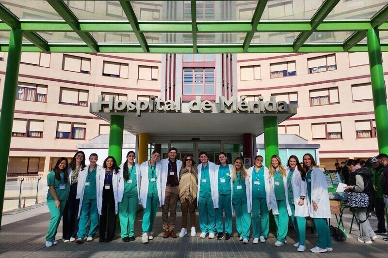 people wearing medical scrubs standing outside a hospital