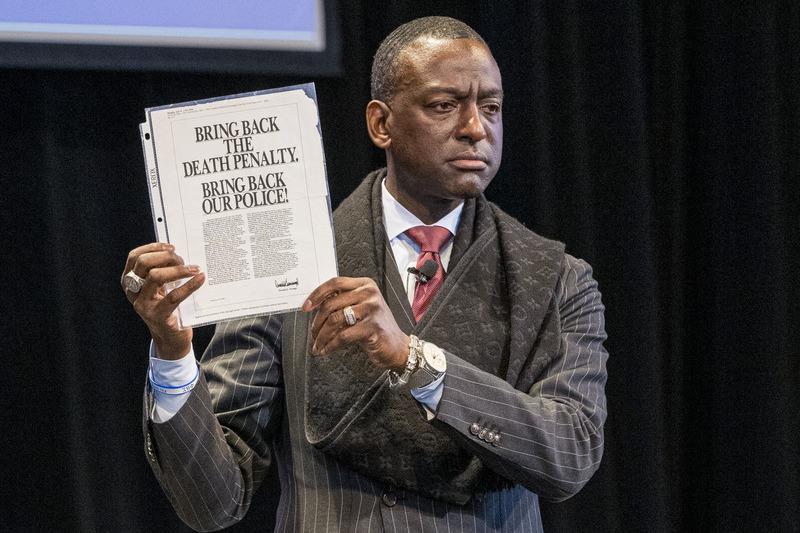 Yusef Salaam holding up an ad that reads "Bring back the death penalty. Bring back our police!"