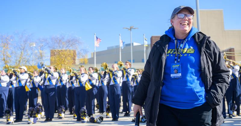 Heidi Sarver stadning in front of UD Marching Band